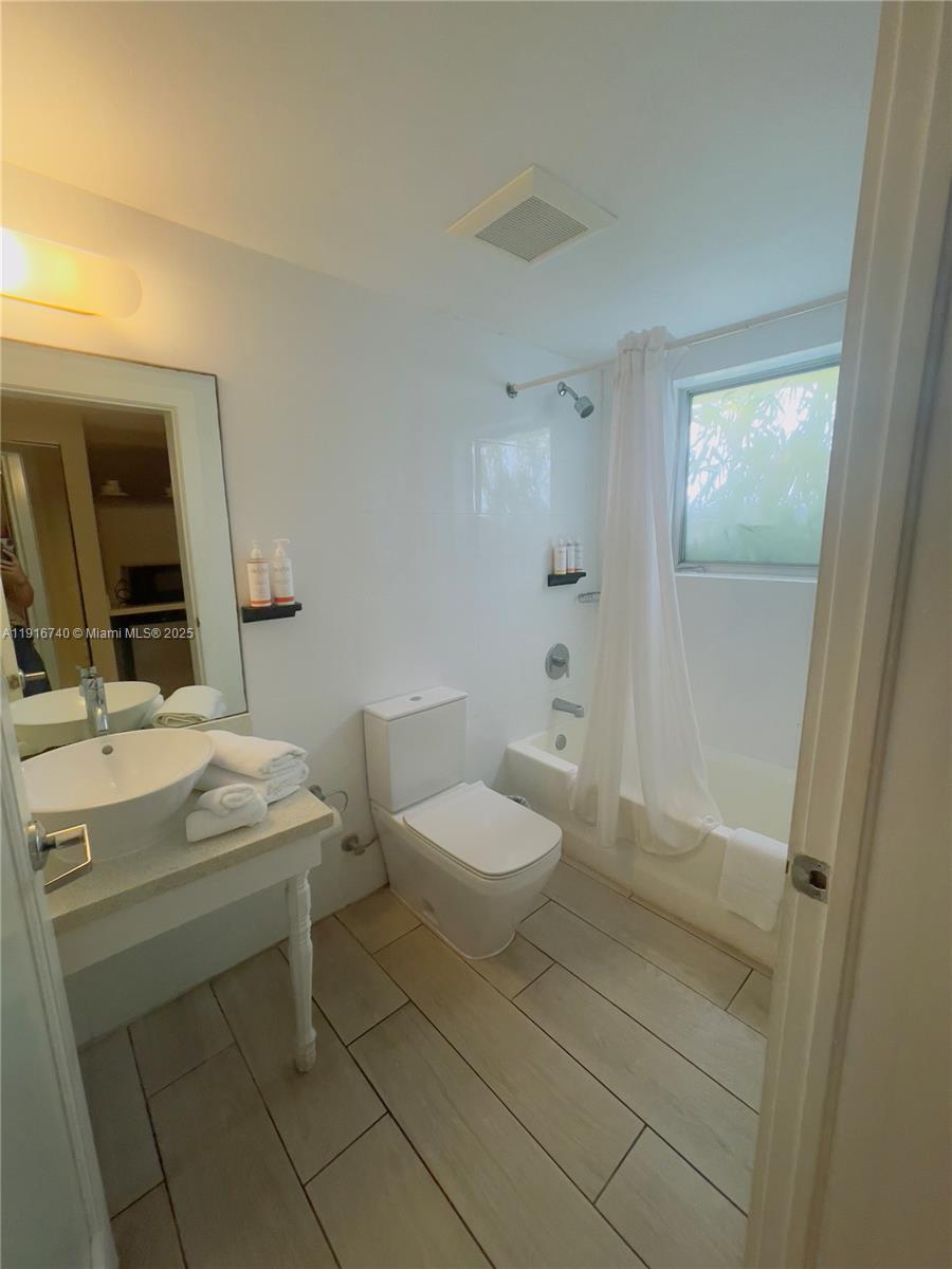 7310 Harding Avenue, Unit 309 Miami Beach, FL 33141 - Photo 6 of 8 a bathroom with a sink toilet and mirror