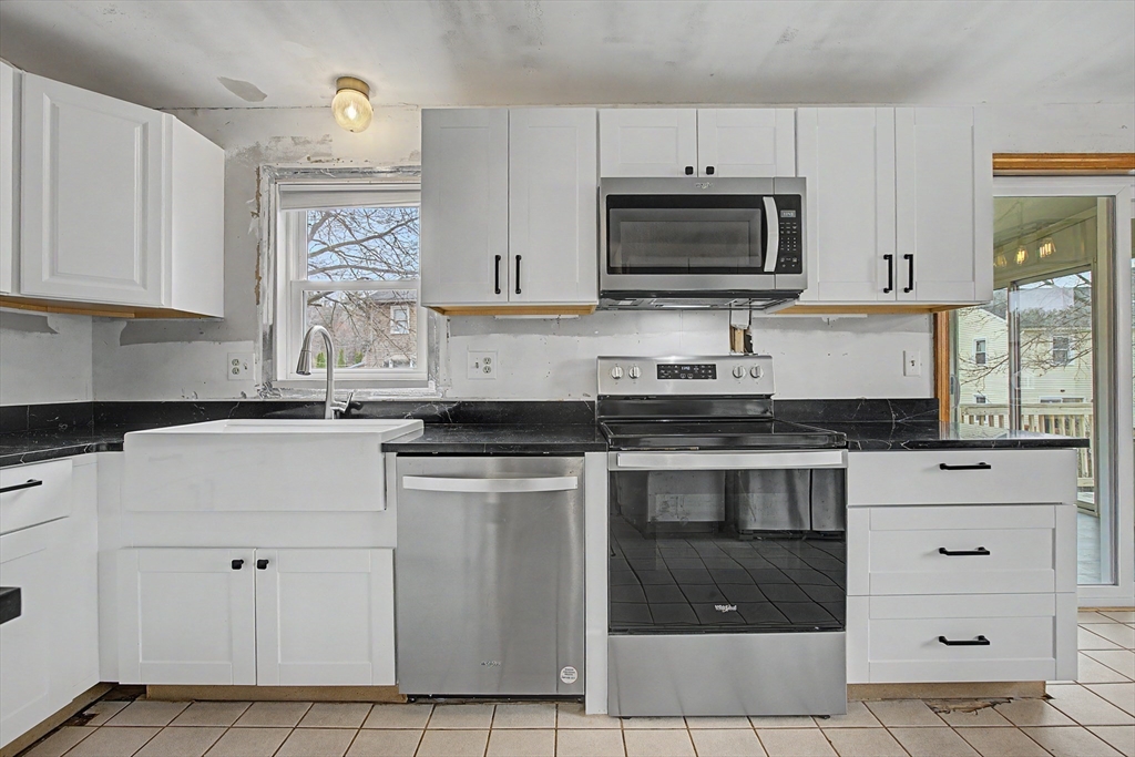 19 R Brian Avenue Derry, NH 03038 - Photo 4 of 37 a kitchen with stainless steel appliances granite countertop a stove a sink and a microwave