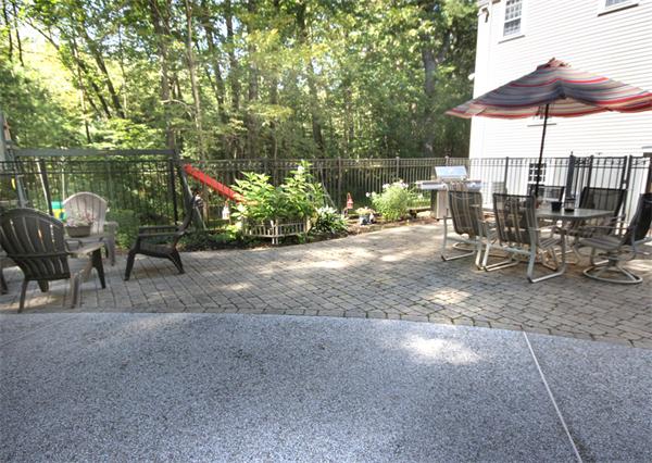 50 Towne Road Boxford, MA 01921 - Photo 23 of 30 a view of a patio with table and chairs under an umbrella with a small yard