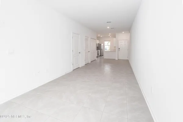 a view of a hallway with closet and a window