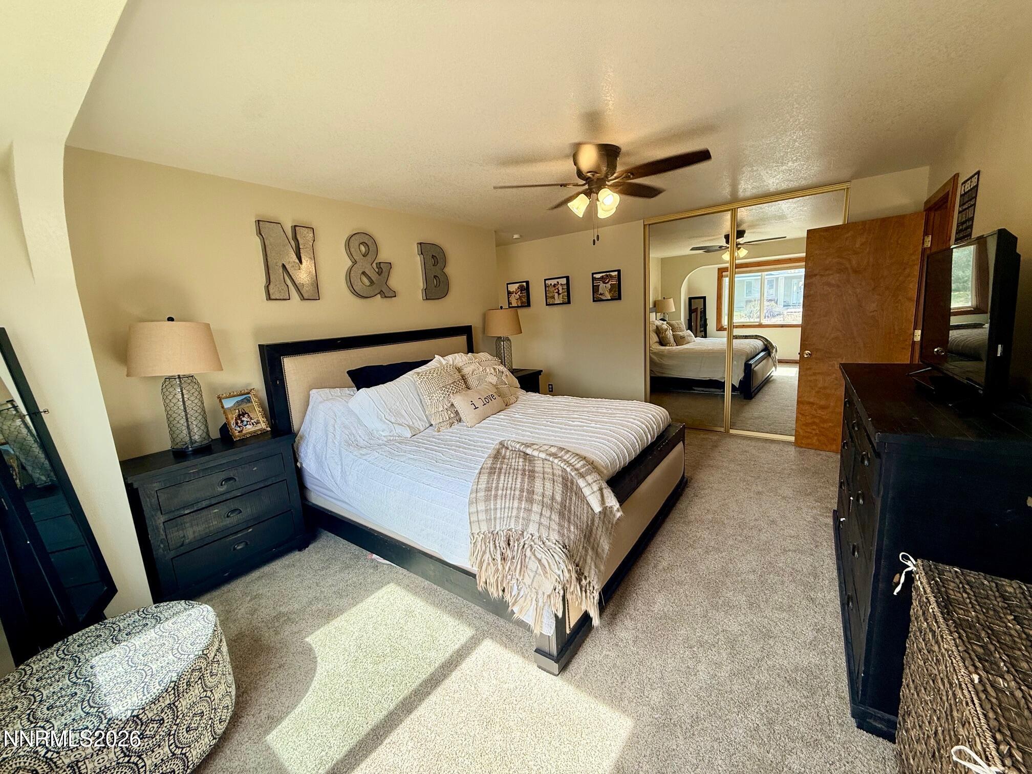 4734 Killdeer Road Carson City, NV 89701 - Photo 30 of 40 a spacious bedroom with a bed a couch and dresser