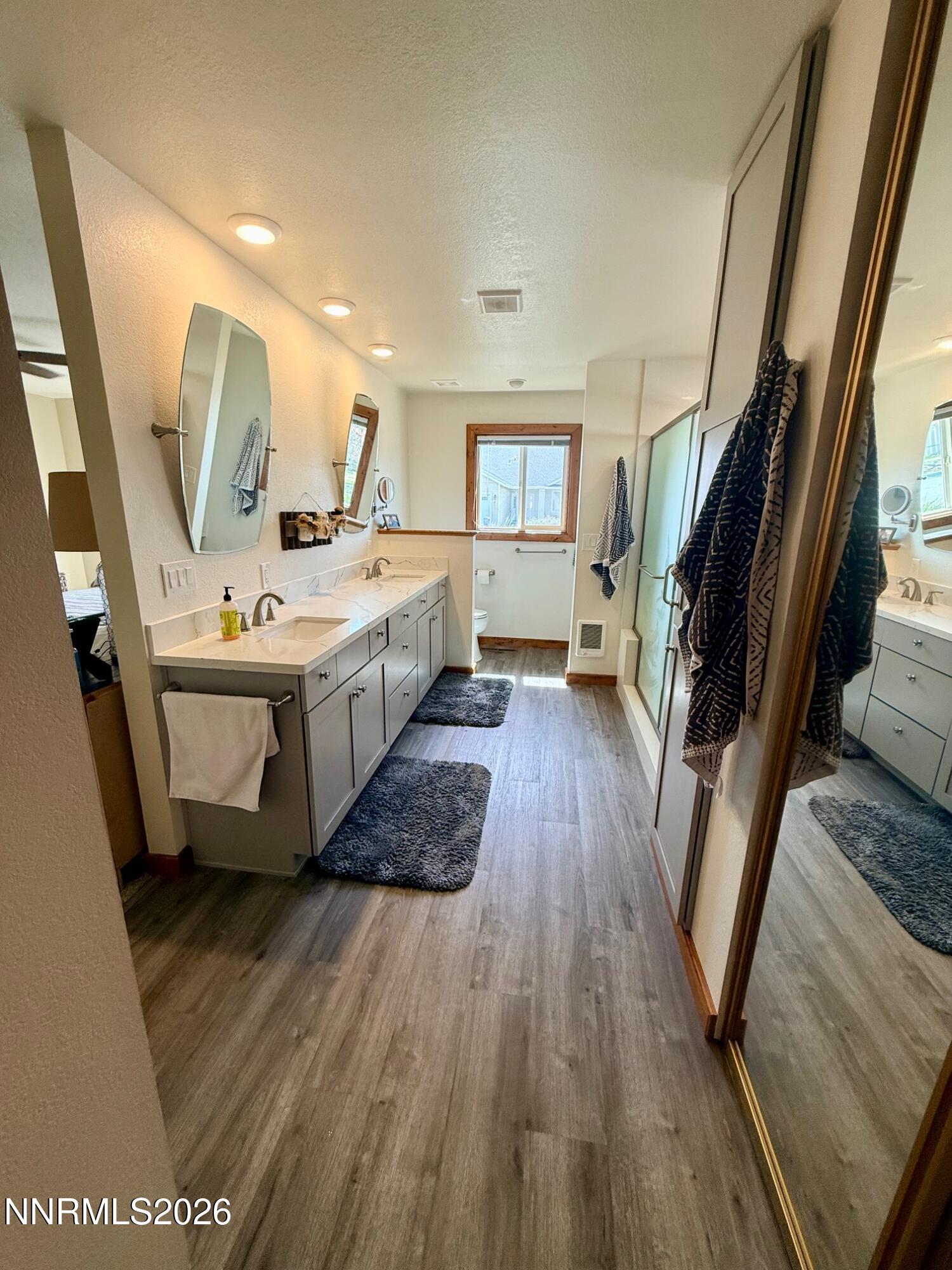4734 Killdeer Road Carson City, NV 89701 - Photo 33 of 40 a large bathroom with a sink a mirror and wooden floor