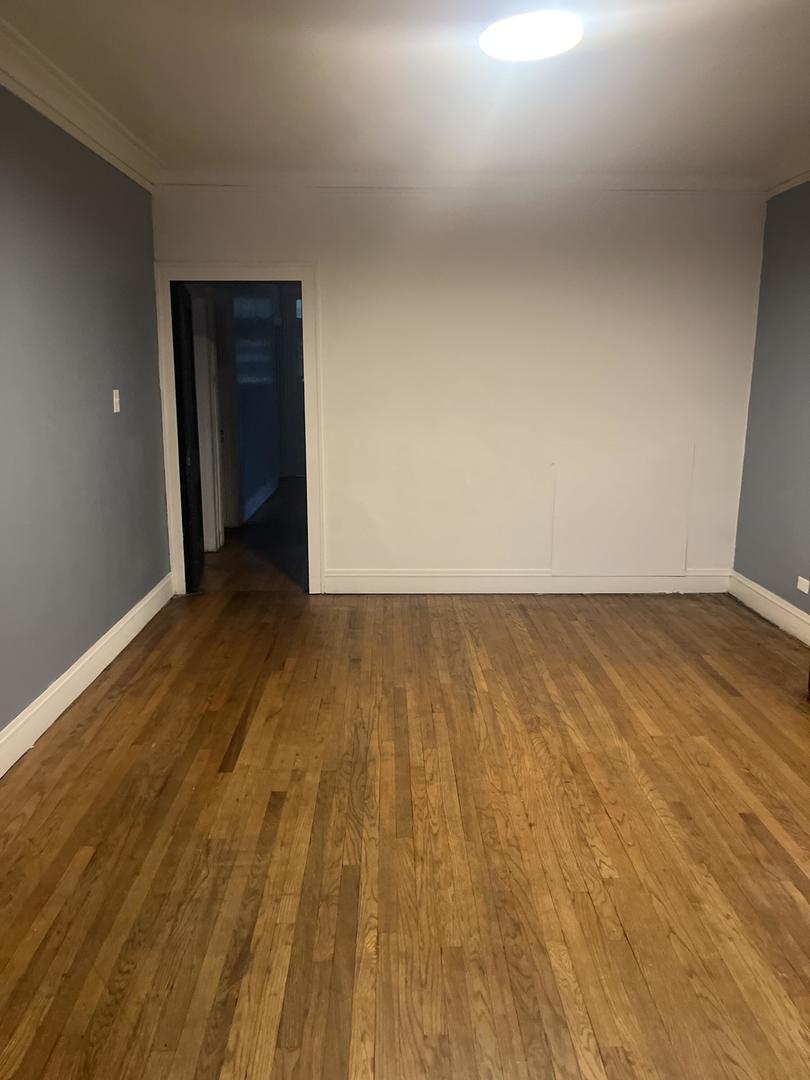237 West 114th Street Chicago, IL 60628 - Photo 11 of 27 a view of an empty room and wooden floor