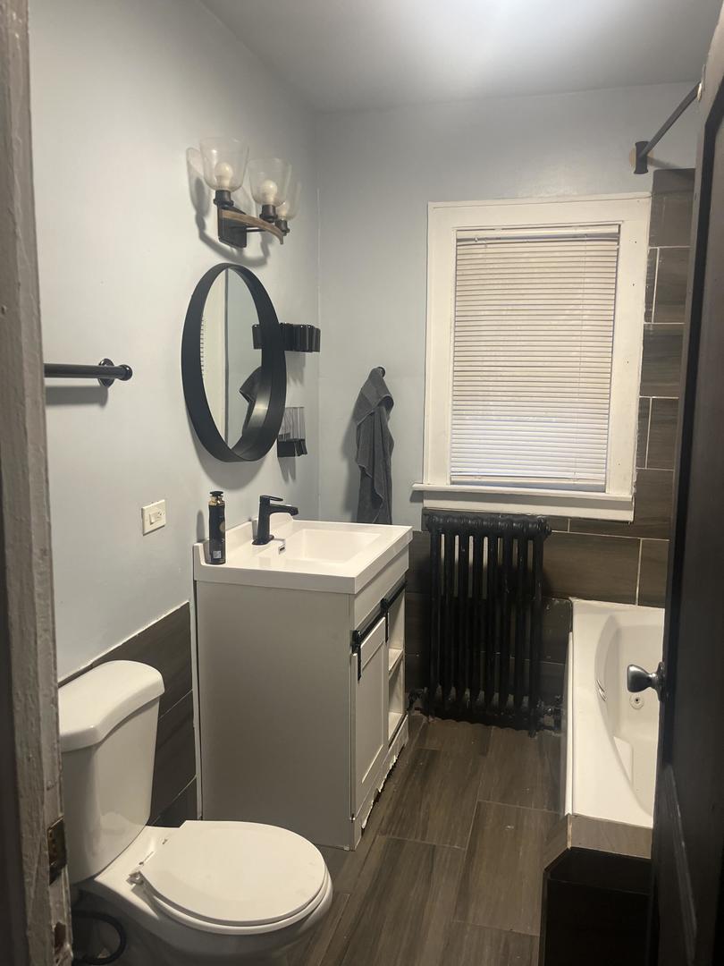 237 West 114th Street Chicago, IL 60628 - Photo 7 of 27 a bathroom with a toilet a sink and a mirror