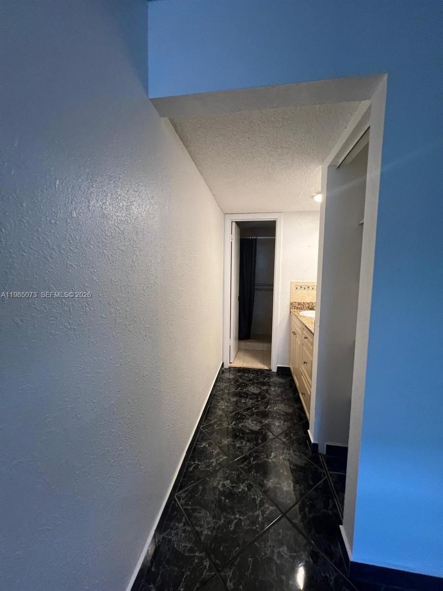 1900 West 68th Street, Unit D207 Hialeah, FL 33014 - Photo 27 of 33 a view of a hallway with wooden floor and a bathroom