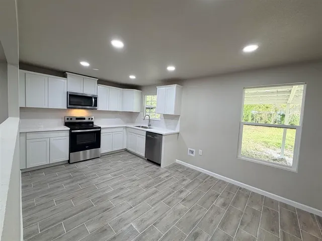 a kitchen with granite countertop a refrigerator and a sink