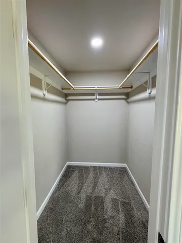 an empty room with a window and a ceiling fan