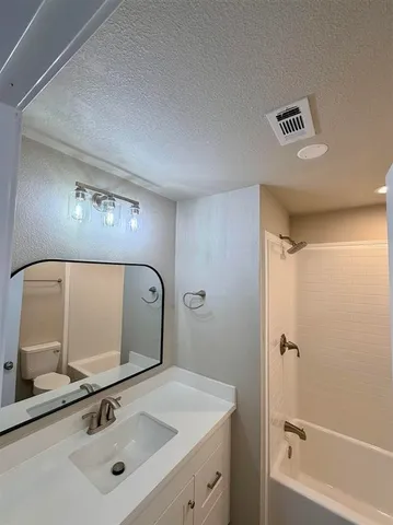 a view of a house with a yard and large trees