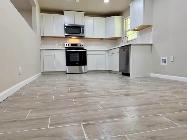 a kitchen with stainless steel appliances granite countertop a stove a sink and a refrigerator