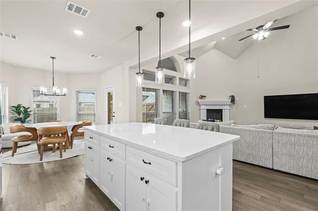 a kitchen with granite countertop white cabinets and white appliances