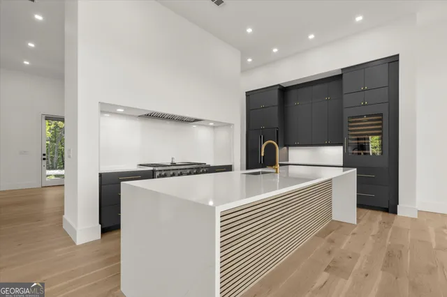 a view of an empty room with wooden floor and a bathroom