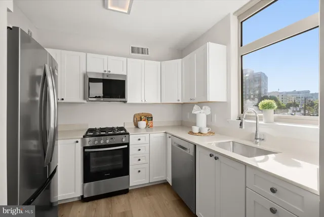 a kitchen with stainless steel appliances granite countertop a stove a sink and a microwave