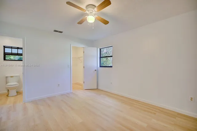 wooden floor in an empty room with a fan