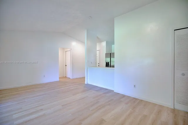 a view of a room with wooden floor and a bathroom