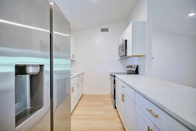 a kitchen with white cabinets and white appliances