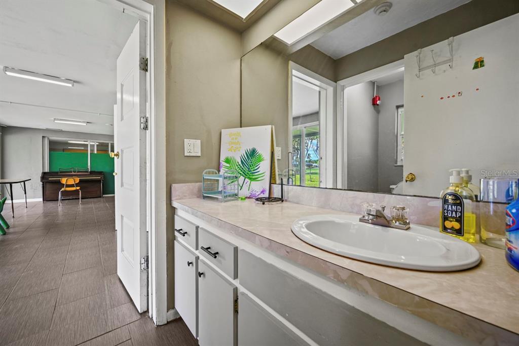 101 St Andrews Boulevard Naples, FL 34113 - Photo 13 of 34 a en suite bathroom with a granite countertop sink and a mirror