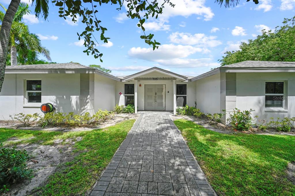 101 St Andrews Boulevard Naples, FL 34113 - Photo 3 of 34 a front view of house with yard and green space