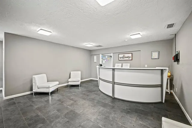 a living room with a sink and a refrigerator