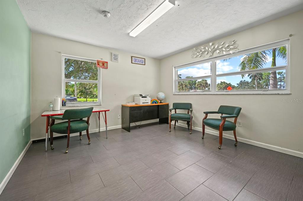 101 St Andrews Boulevard Naples, FL 34113 - Photo 6 of 34 a reading room with furniture a window and a bookshelf