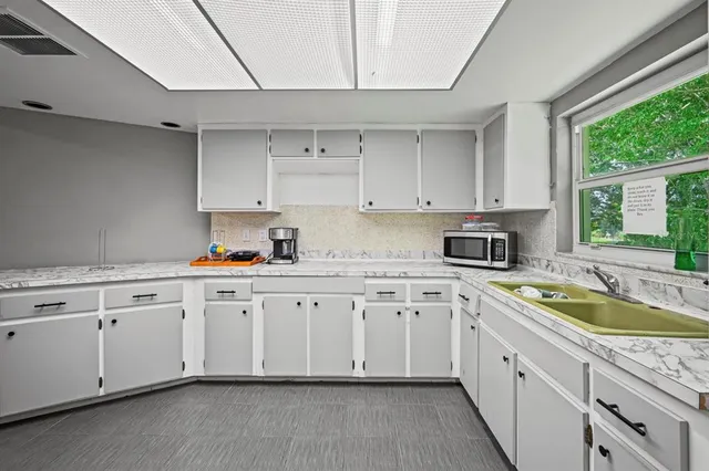 a kitchen with white cabinets and refrigerator