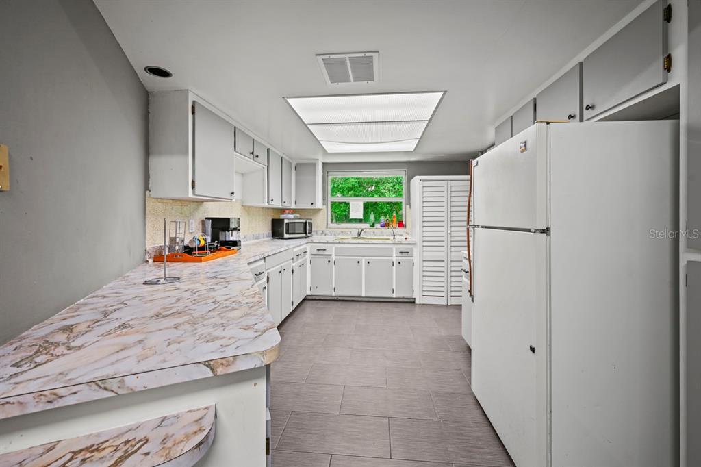 101 St Andrews Boulevard Naples, FL 34113 - Photo 10 of 34 a kitchen with stainless steel appliances a refrigerator sink and cabinets