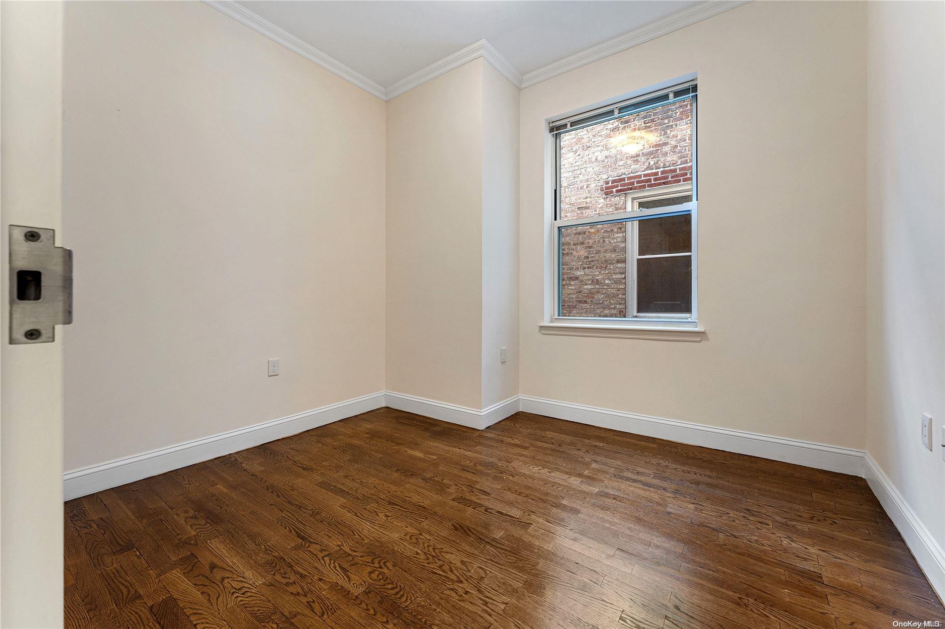 5112 Post Road Bronx, NY 10471 - Photo 12 of 35 a view of an empty room with wooden floor and a window