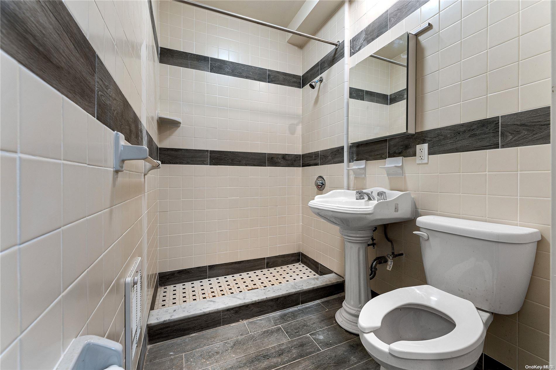 5112 Post Road Bronx, NY 10471 - Photo 30 of 35 a bathroom with a sink a toilet and a mirror