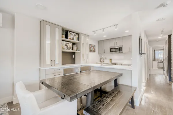 a kitchen with a table chairs sink and cabinets