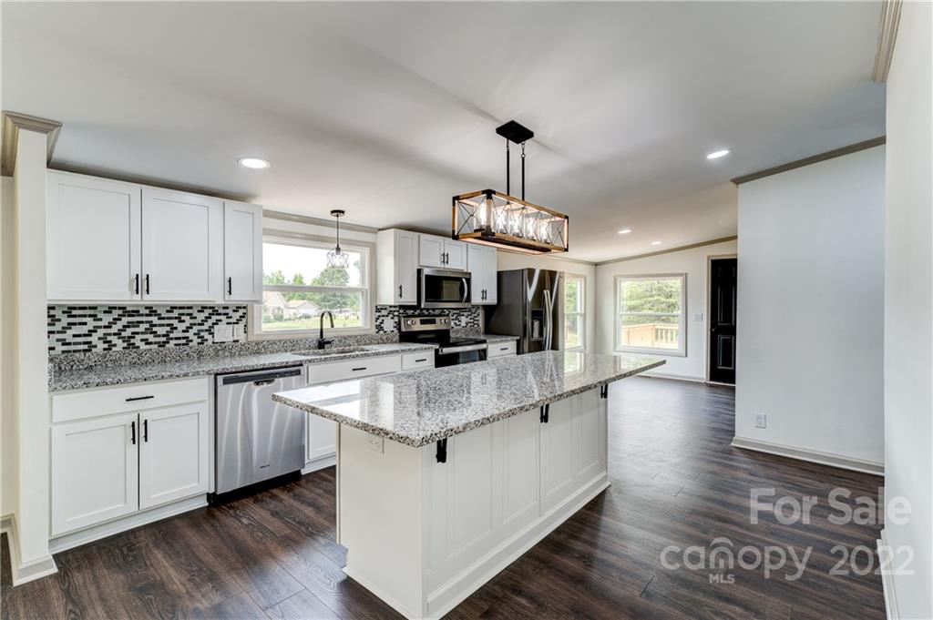 1569 Lawrence Road Clover, SC 29710 - Photo 8 of 26 a large kitchen with stainless steel appliances granite countertop a sink a stove and a wooden floors