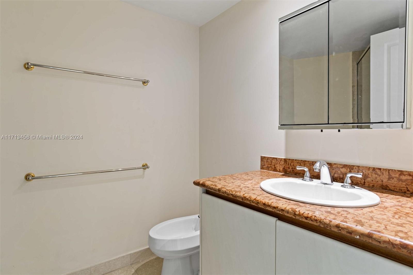 2127 Brickell Avenue, Unit 2804 Miami, FL 33129 - Photo 32 of 72 a bathroom with a granite countertop sink and a toilet