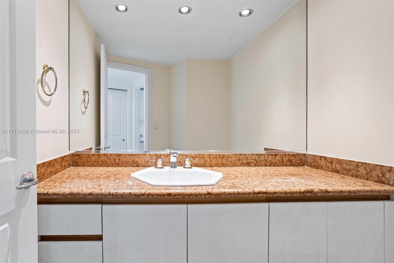 2127 Brickell Avenue, Unit 2804 Miami, FL 33129 - Photo 36 of 72 a bathroom with a granite countertop sink and a mirror