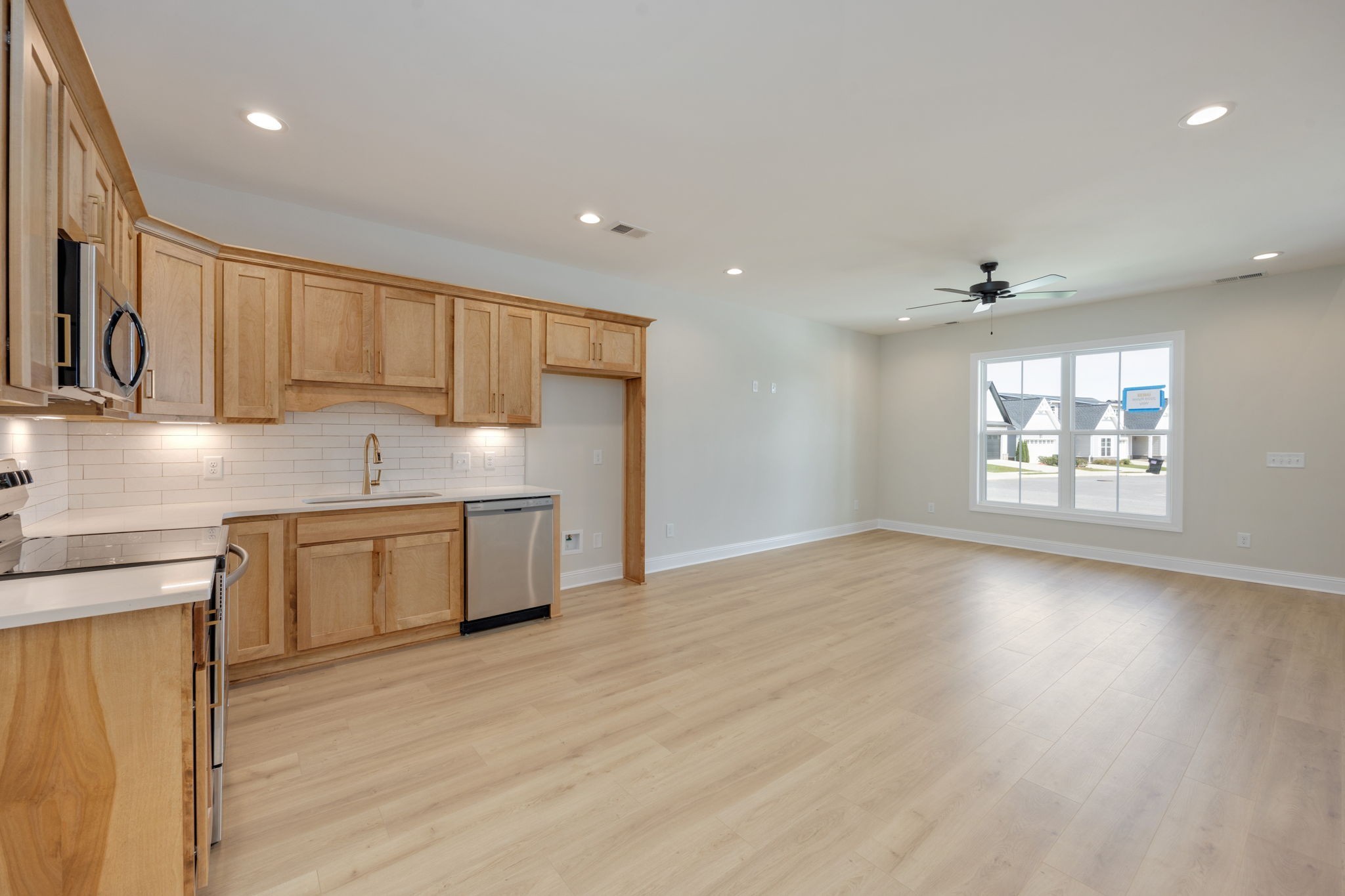 2009 Rylee Way, Unit 22 Greenbrier, TN 37073 - Photo 14 of 28 a kitchen with stainless steel appliances granite countertop a stove a sink and a refrigerator with wooden floors