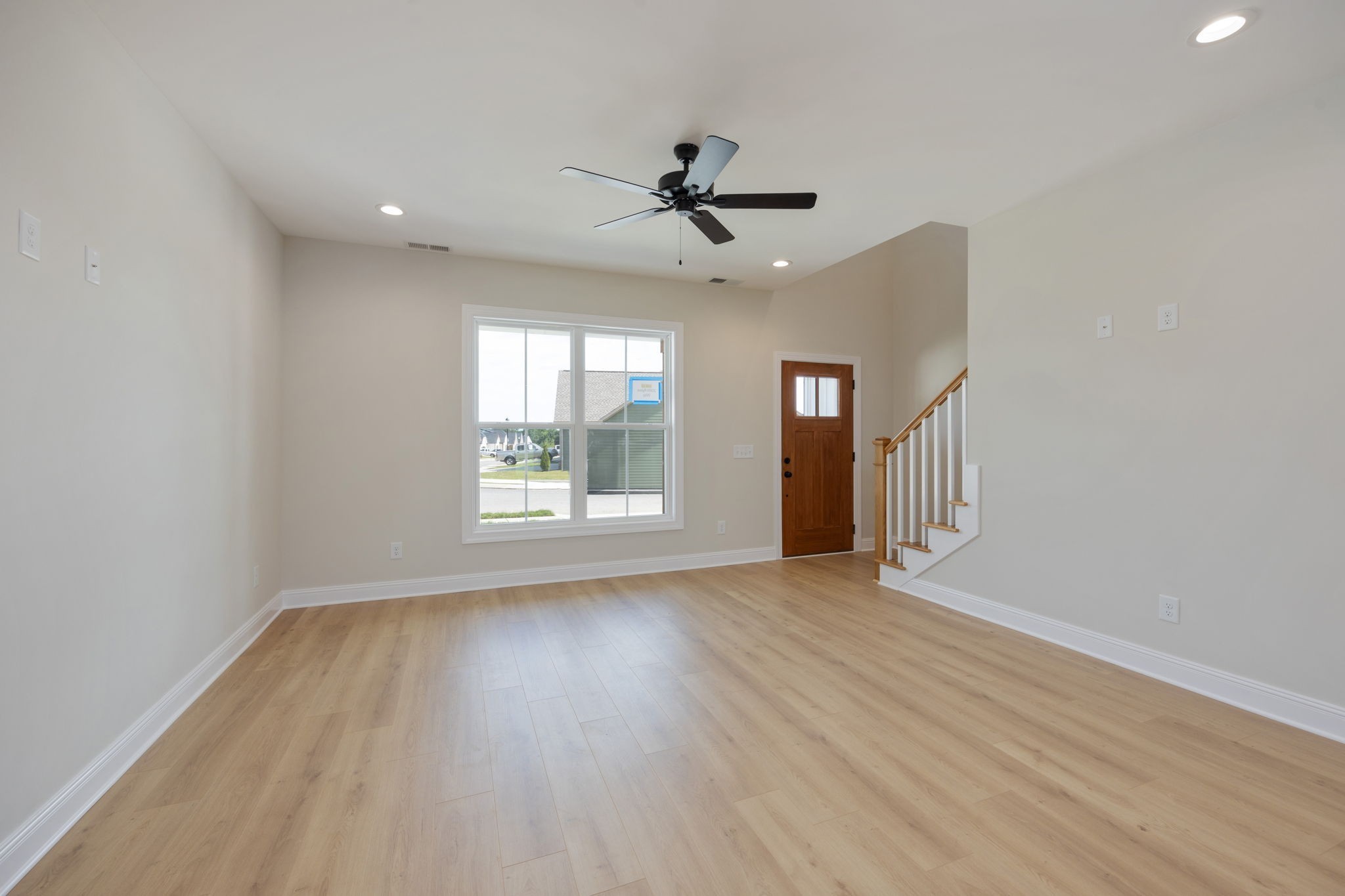 2009 Rylee Way, Unit 22 Greenbrier, TN 37073 - Photo 10 of 28 an empty room with wooden floor chandelier fan and windows