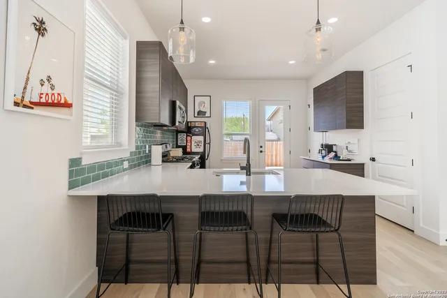 a kitchen with cabinets table and chairs