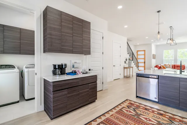 a kitchen with stainless steel appliances kitchen island granite countertop a sink a stove a refrigerator and cabinets