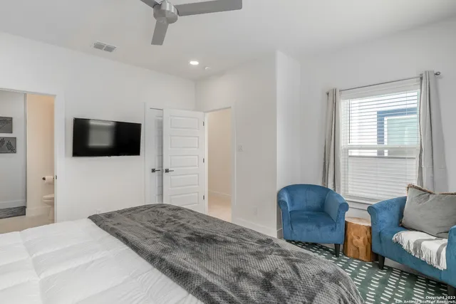 a bedroom with a bed furniture and a flat screen tv