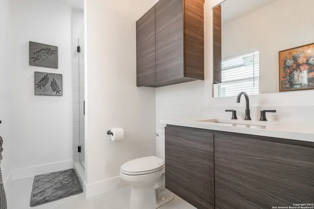 a bathroom with a toilet a sink and mirror