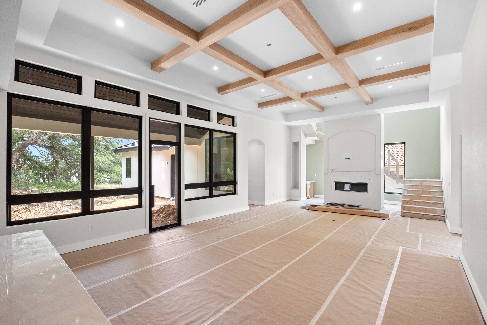 903 Flint Ridge Trail Georgetown, TX 78628 - Photo 5 of 39 Spacious living area featuring a coffered ceiling with wood beams, recessed lighting, a built-in fireplace, and large black-framed windows