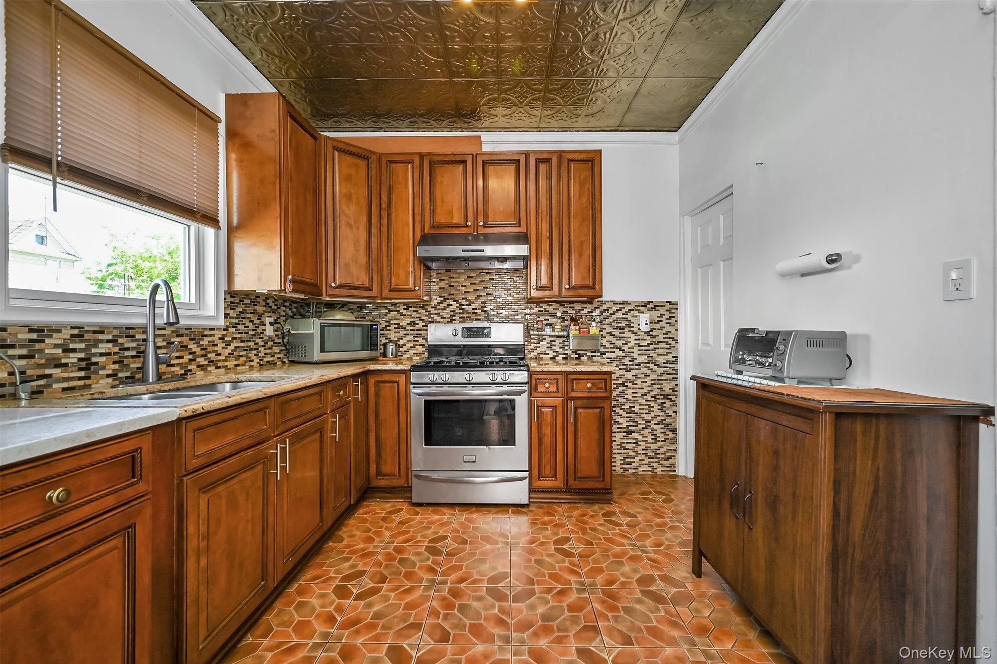 87-71 111th Street Queens, NY 11418 - Photo 6 of 17 a kitchen with stainless steel appliances a stove sink and cabinets
