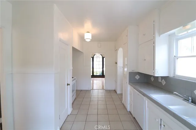 a view of a hallway with granite countertop a couch and a window