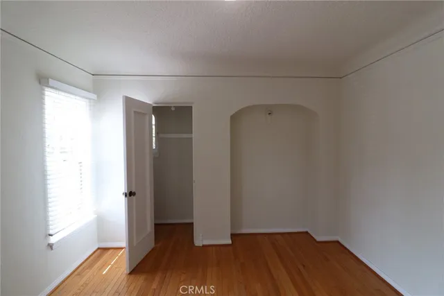a view of a room with wooden floor and a window