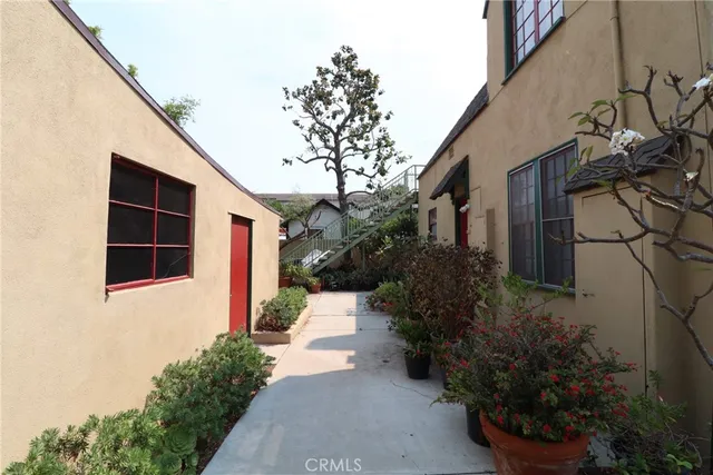 a view of a house with a yard and potted plants