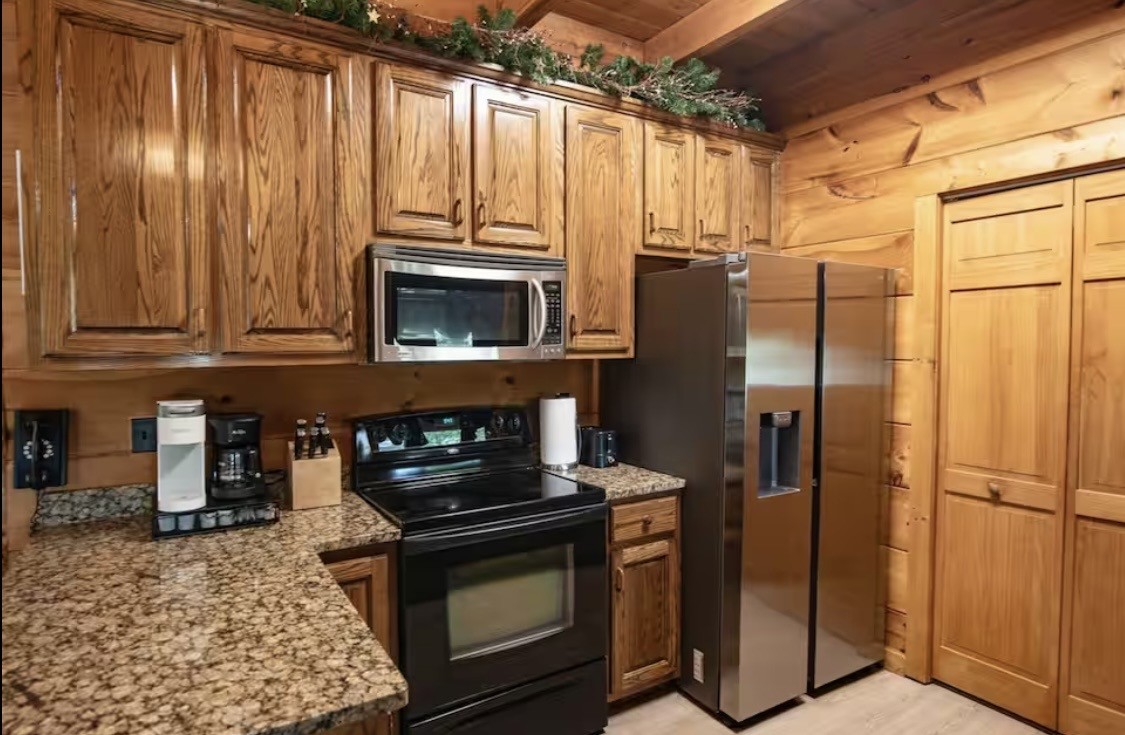 298 Eagle Lake Road Coalmont, TN 37313 - Photo 7 of 38 a kitchen with granite countertop a refrigerator stove and microwave
