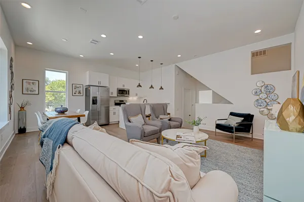 a living room with furniture and a refrigerator