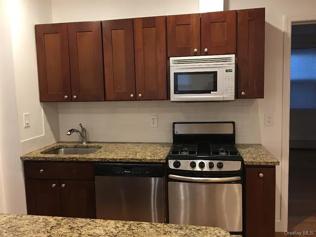 a kitchen with granite countertop a stove and a sink