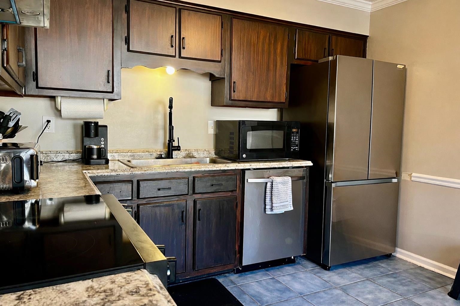3507 Chowning Road Memphis, TN 38135 - Photo 6 of 17 Kitchen featuring light countertops, black appliances, dark brown cabinets, tile patterned flooring, and ornamental molding