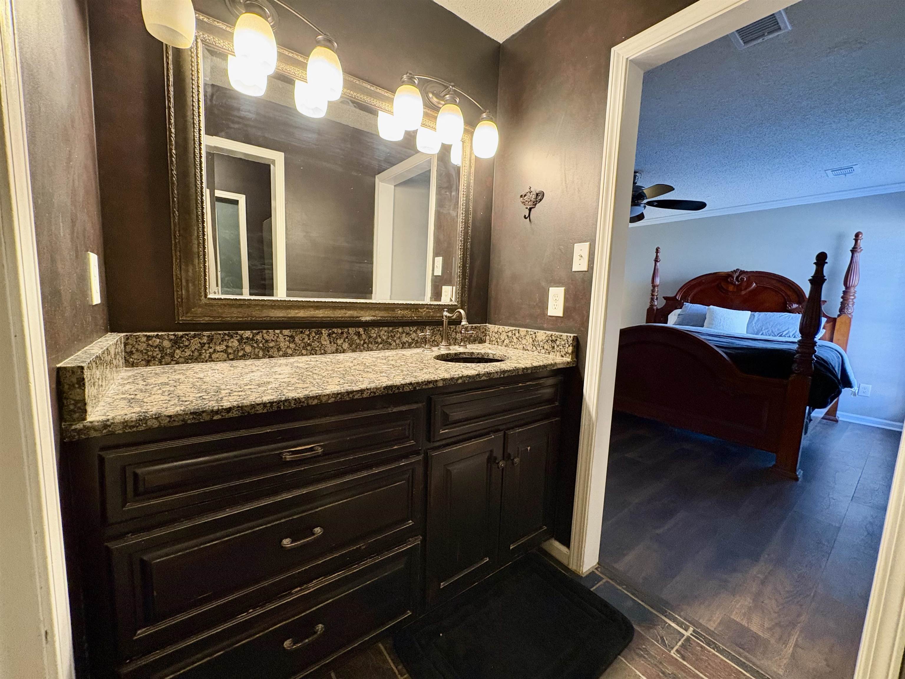 3507 Chowning Road Memphis, TN 38135 - Photo 10 of 17 Bathroom with vanity, dark wood-style floors, a textured ceiling, ceiling fan, and connected bathroom