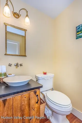 a bathroom with a sink a toilet and mirror