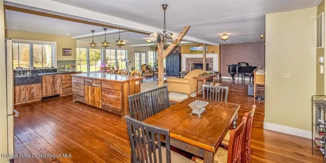 a view of a dining room and livingroom with furniture wooden floor a chandelier