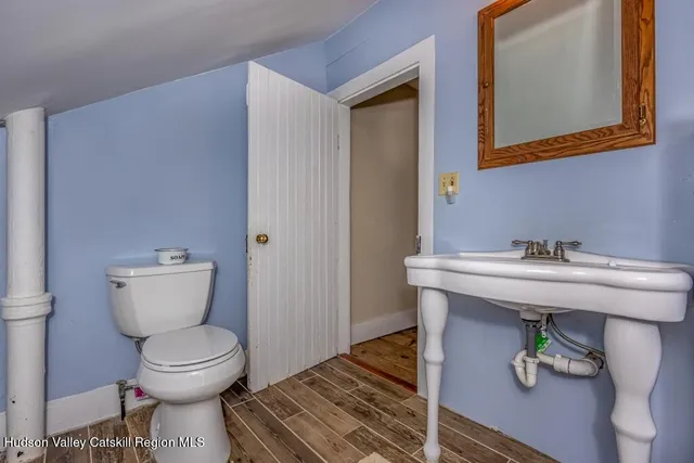 a bathroom with a toilet sink and mirror